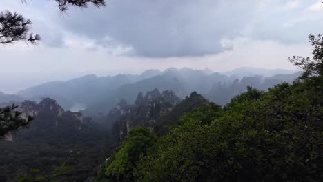 Pan left showing forested mountains of Zhangjiajie under thick clouds and soft diffused light