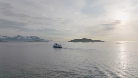 Ferry-Sailing-From-Brensholmen-During-Spring-In-Northern-Norway---aerial-drone-shot