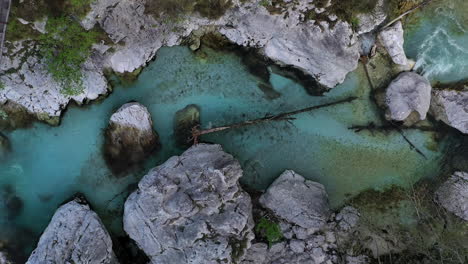 Vista-De-Arriba-Hacia-Abajo-Del-Río-Soča-En-Eslovenia-Mientras-El-Dron-Se-Eleva-Para-Revelar-El-Paisaje