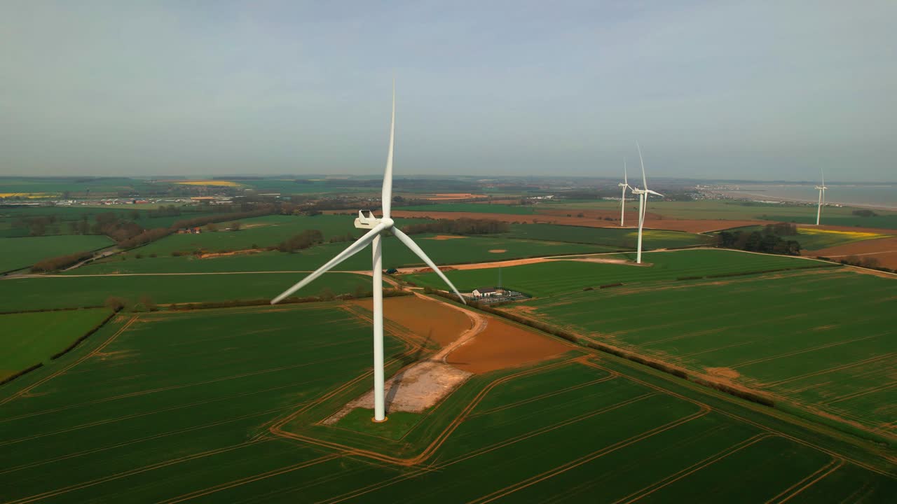 Lissett airfield rotating wind turbine farm on agricultural farmland aerial static view Yorkshire countryside