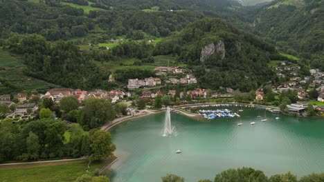 celestial holiday location with houses and roads along shoreline of the lake parked boats providing an extra layer of texture and depth to this beautiful landscape magnificent mountains in switzerland