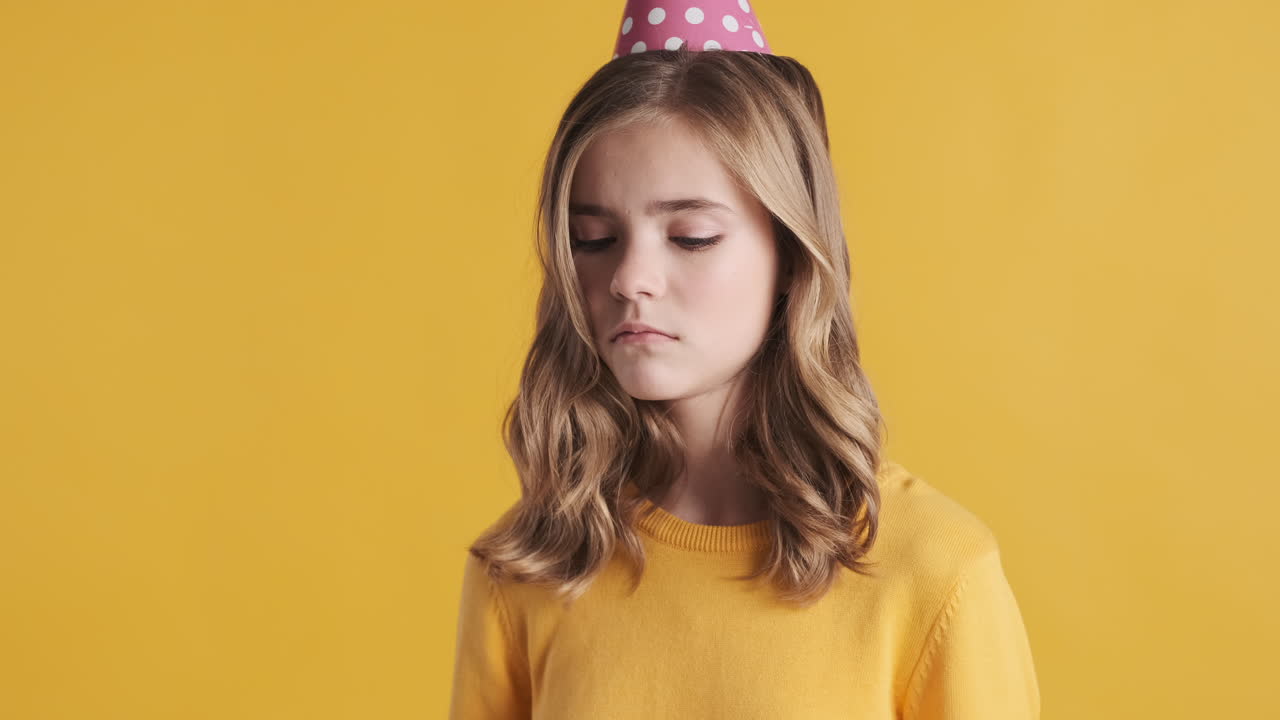 파티 모자를 입은 슬픈 십대 백인 소녀.