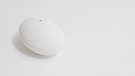 white rugby ball on white background with copy space, slow motion