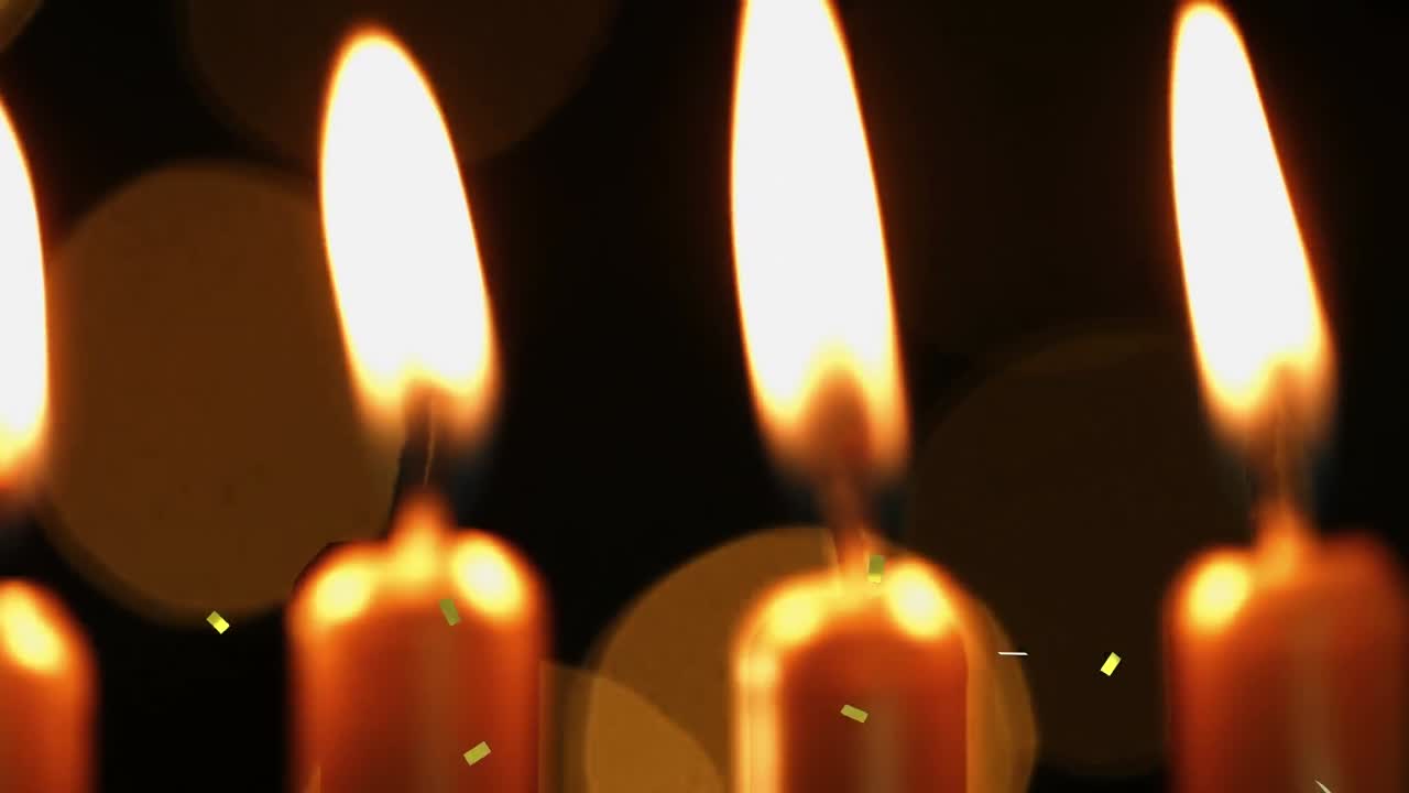 animación de confeti de oro cayendo sobre velas de pastel de cumpleaños encendidas y luces bokeh