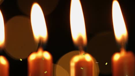 Animation-of-gold-confetti-falling-over-lit-birthday-cake-candles-and-bokeh-lights