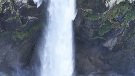 pan de una hermosa cascada alta salpicando en las rocas de abajo