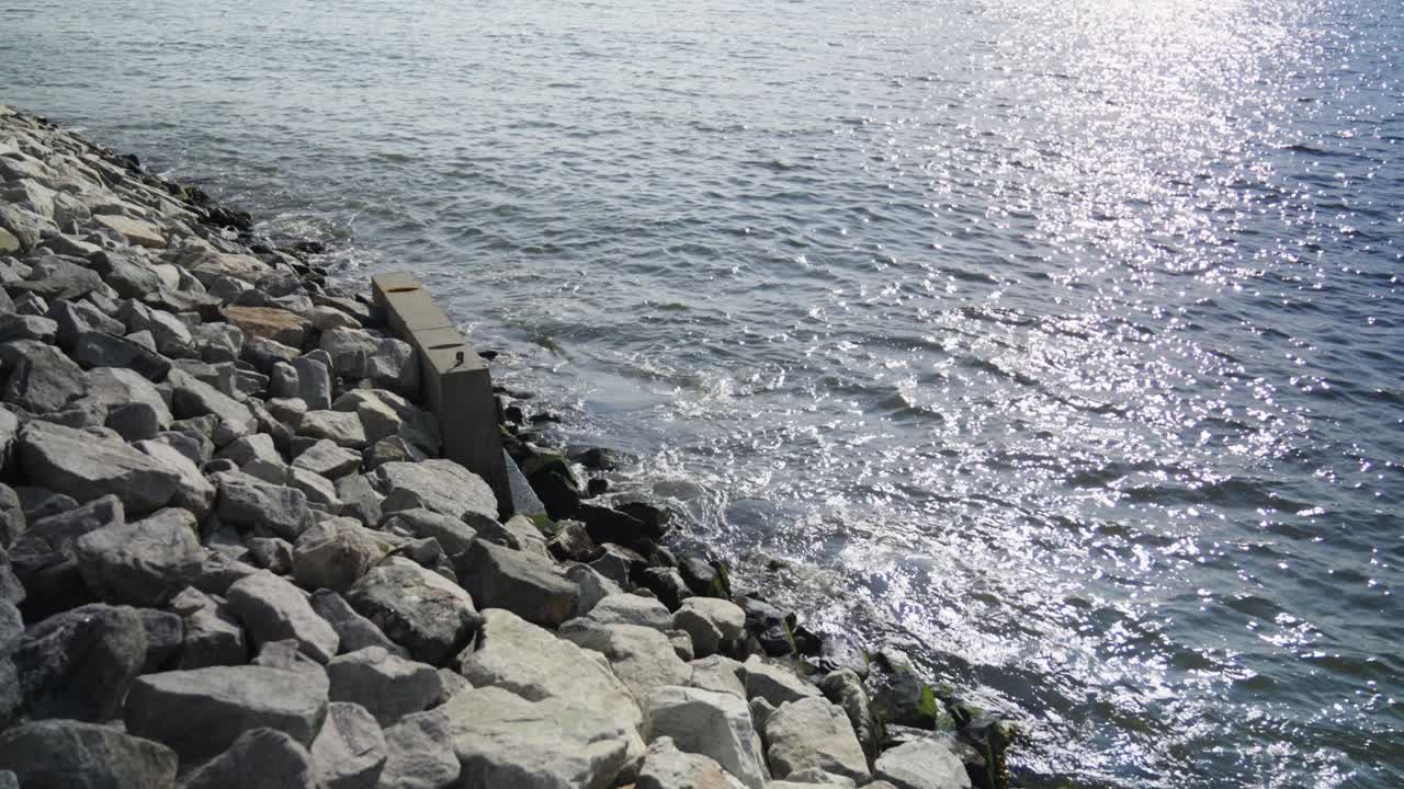 The East River's mighty waves crash against a concrete retaining wall on Brooklyn's jetty