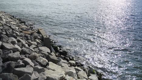 the east river's mighty waves crash against a concrete retaining wall on brooklyn's jetty