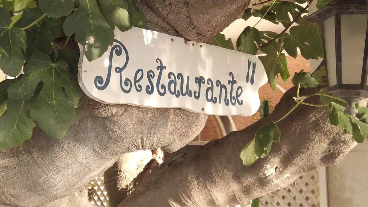 cartel de restaurante colgado en una higuera