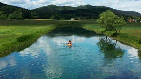 adventurer travels down gacka river by kayak, lika, croatia