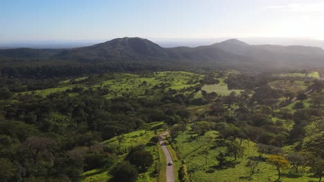 Disparo-De-Un-Dron-Siguiendo-Un-Coche-A-Través-Del-Loco-Paisaje-Verde-Costarricense