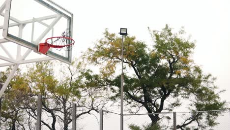 Young-african-player-jumping-up-and-hitting-a-basketball-ring-by-his-hand.-Slow-Motion-shot