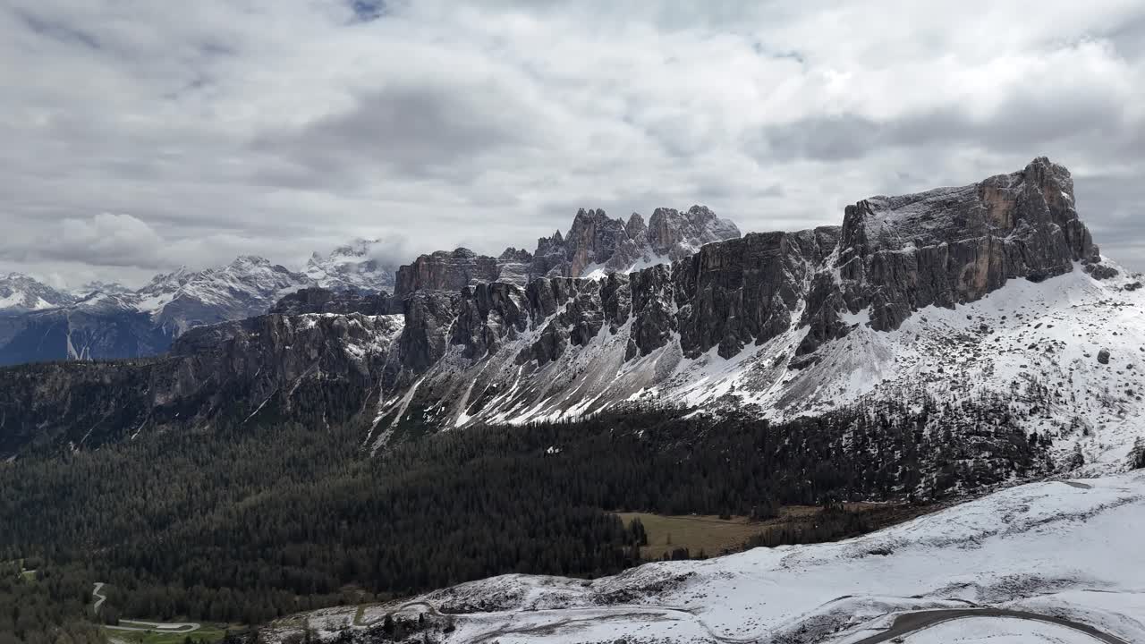 Snowy peaks at Passo Giau in Dolomites with rough cliffs and forest