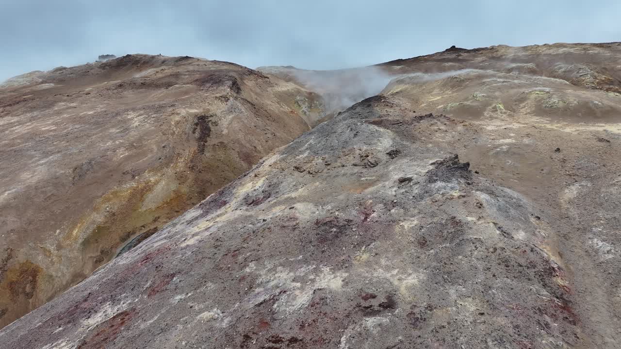 아이슬란드의 지열 지역의 화산 암석과 온천에서 나오는 증기 위를 날아다니는 드론 촬영