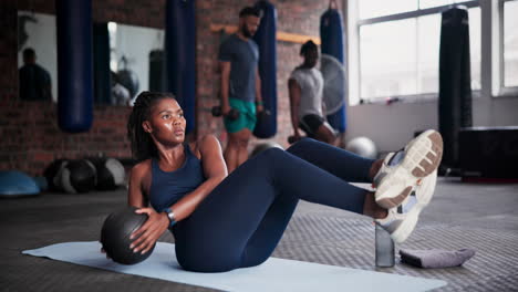 woman doing crunches with exercise ball in gym