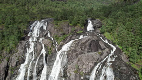 Aerial-shot,-rotating-right-to-left-around-the-top-of-a-wide-waterfall,-Laukelandsfossen,-Norway