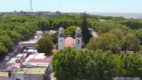 Aerial-orbit-of-an-ancient-church-hidden-among-trees-on-a-sunny-day