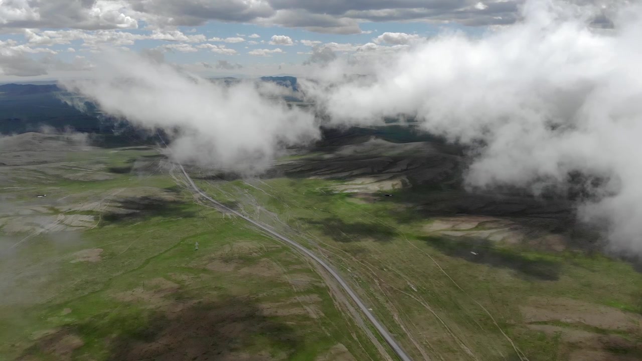 Luftfoto av en svingete vei gjennom en vid grønn dal.