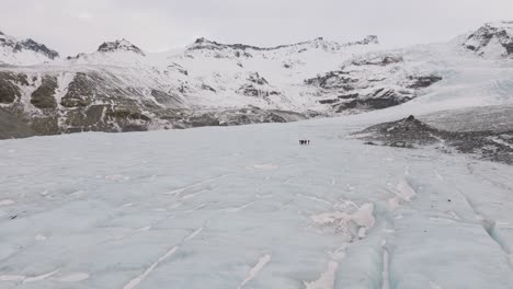 aerial panoramic landscape view of people hiking on the ice surface of virkisjokull glacier, iceland