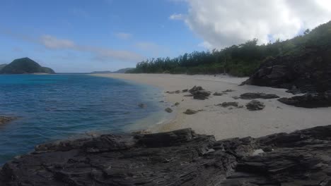 Deserted-Tropical-Island-Beach-With-Rocks-In-Foreground