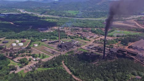 aerial view of dark smoke rising from mine and plant chimneys, polluting the nature - orbit, drone shot