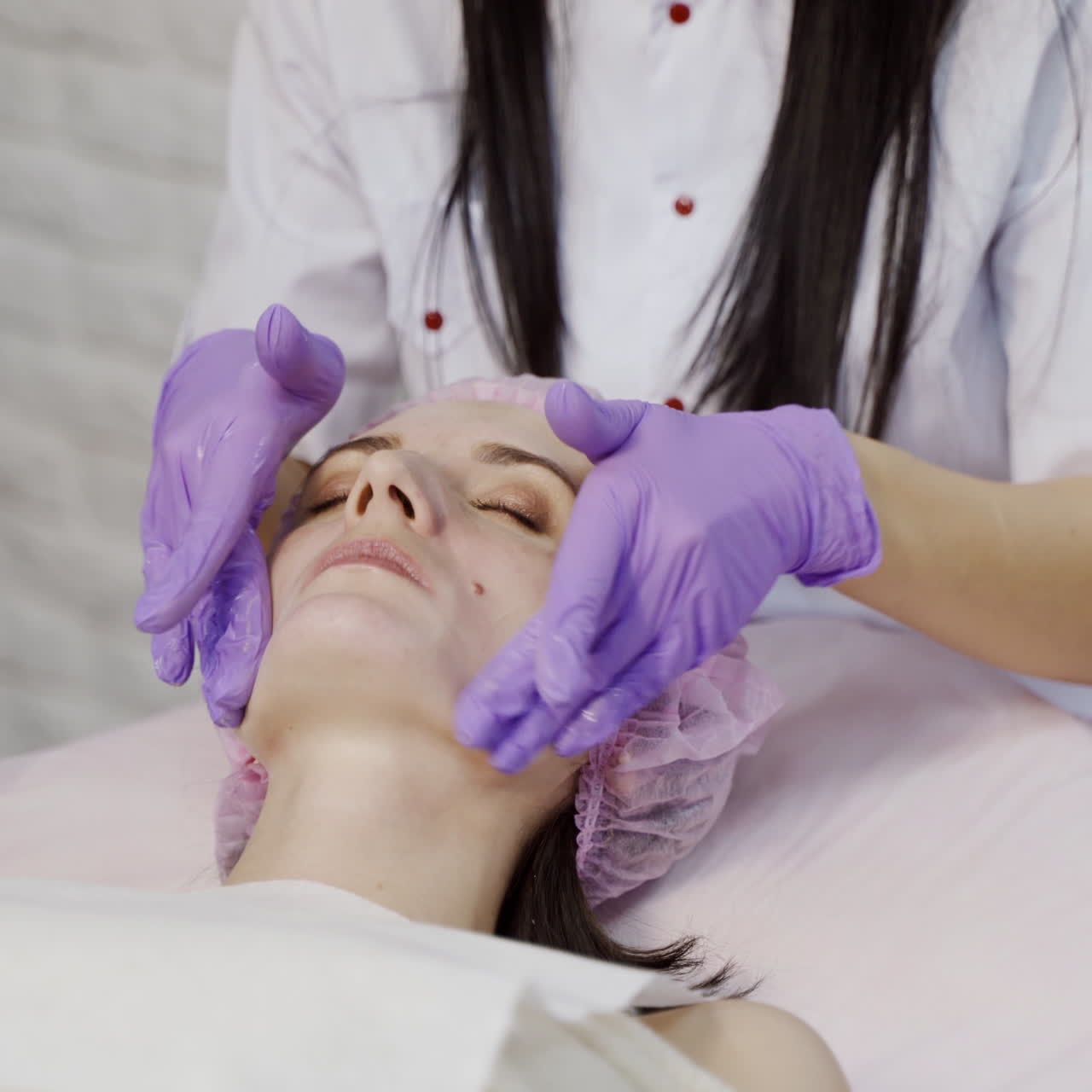Young woman enjoying of facial massage in spa salon. Beauty Treatment