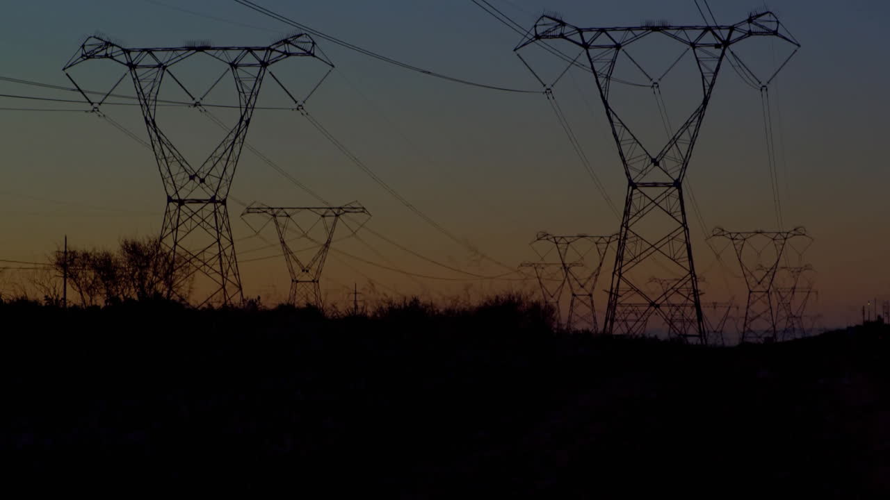 Animation of financial data processing over electric pylons in countryside