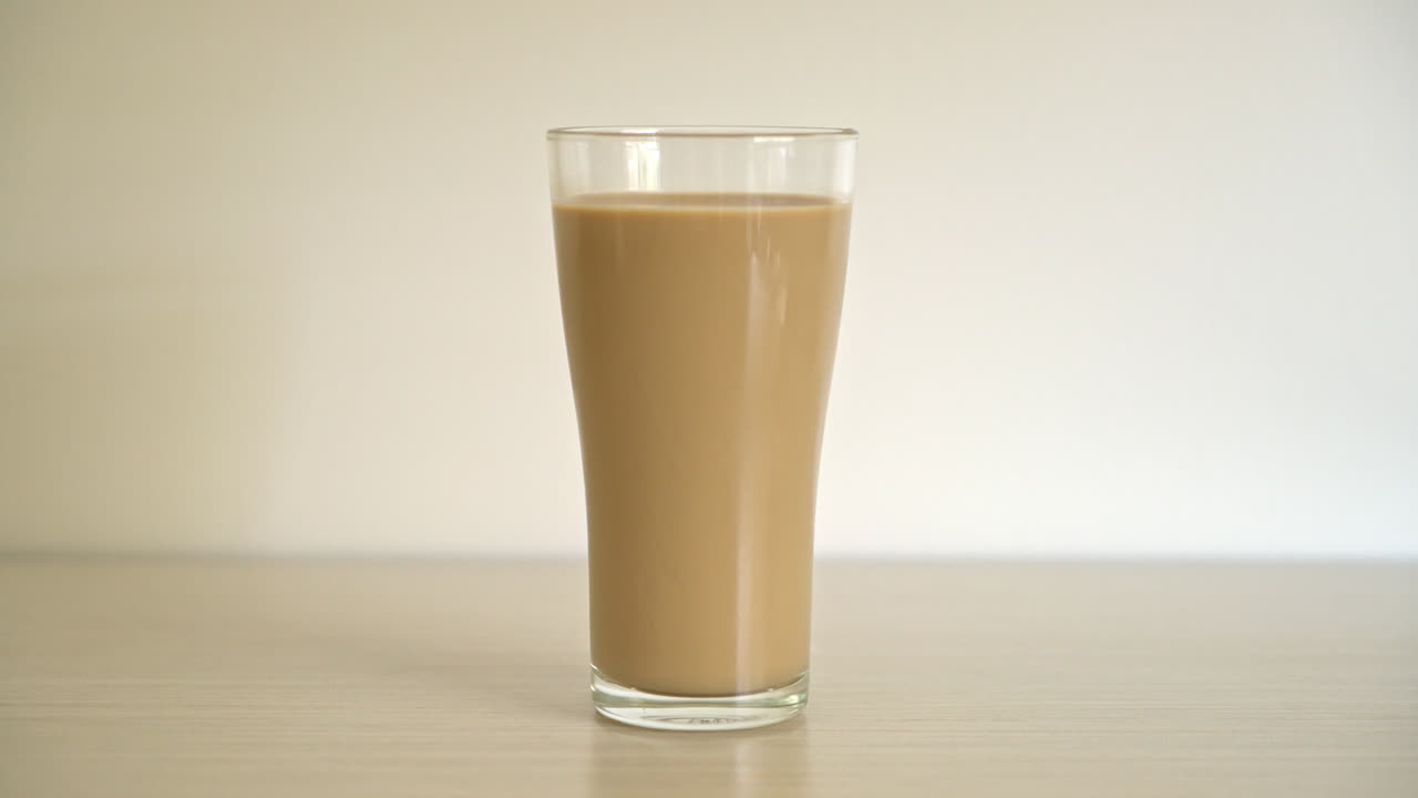 bicchiere di caffè latte con bottiglie di caffè pronte da bere sul tavolo