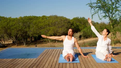 pareja haciendo yoga cerca de la piscina lado 4k