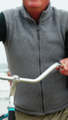 feliz pareja de ancianos caminando con su bicicleta