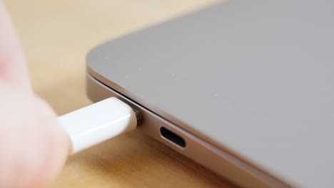 Plugging-usb-c-cable-in-laptop-computer,-close-up