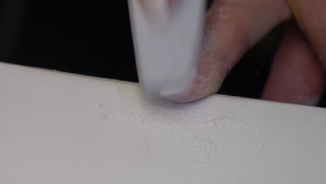 woman polishing fingernails with nail file on table,close up shot