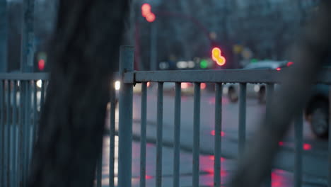 blurred view of a car passing on the road at night, captured with visible traffic lights and street lights in the background