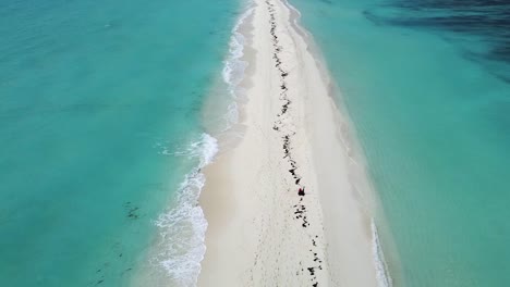drone se eleva sobre un banco de arena en una isla tropical con agua azul clara del océano