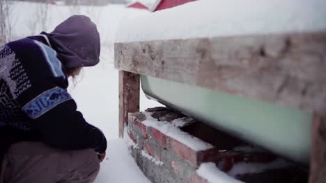 The-Man-is-Brushing-Snow-Off-the-Bricks-and-Placing-Them-Beneath-the-DIY-Hot-Tub---Close-Up