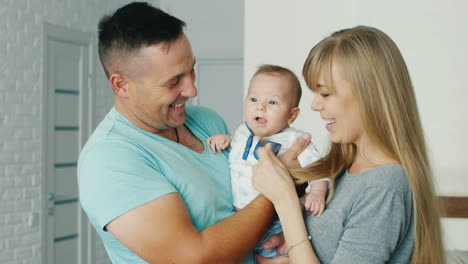 padres jóvenes jugando con su hijo dos meses familia feliz y comodidad en el hogar