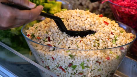 serving a fresh barley salad at a buffet