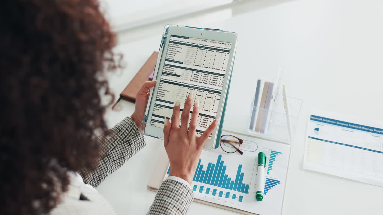 Businesswoman reviewing financial data on tablet