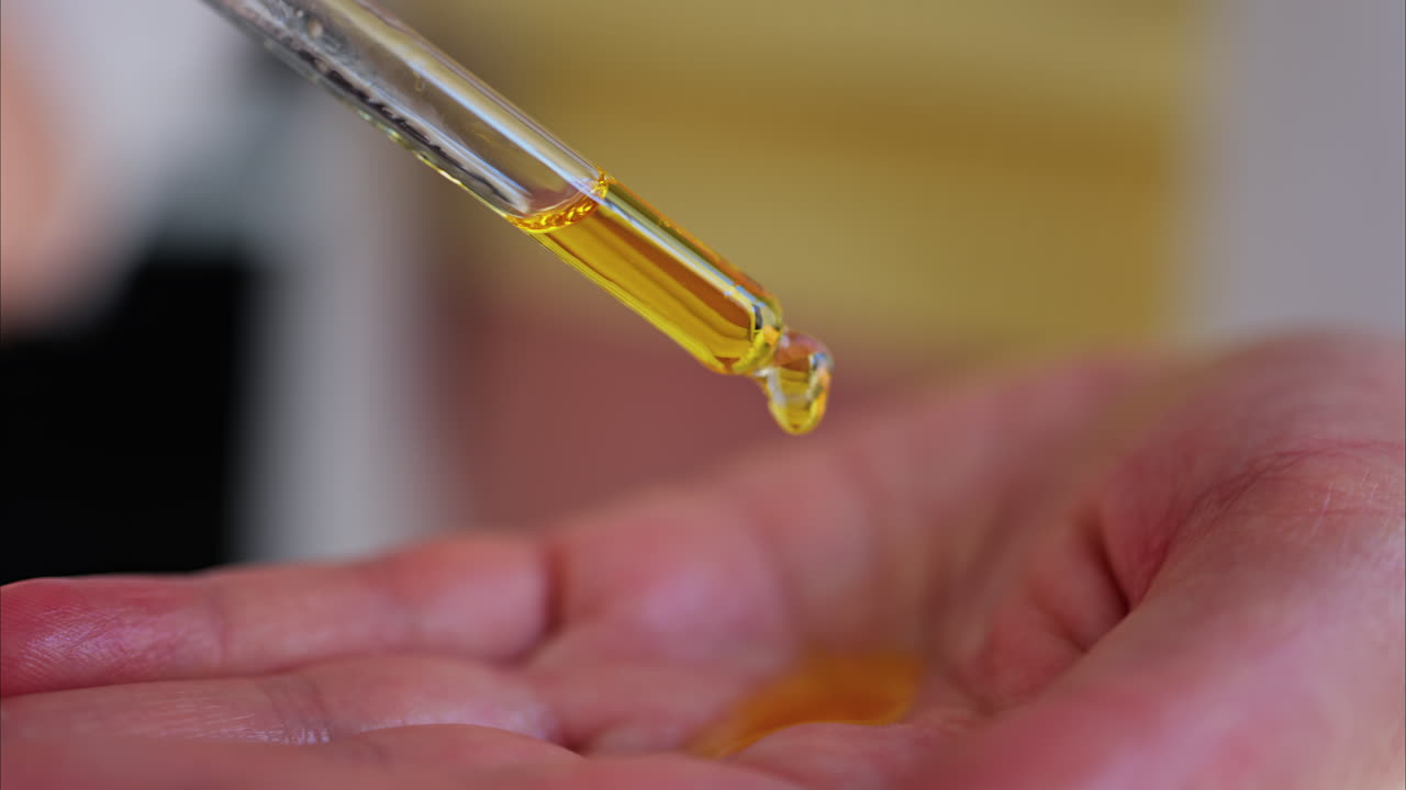 Close up of a pregnant woman poring oil in her hands