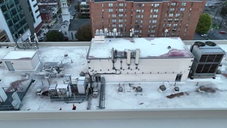 Rooftop-view-of-a-skyscraper-with-HVAC-units-and-cityscape-in-the-background