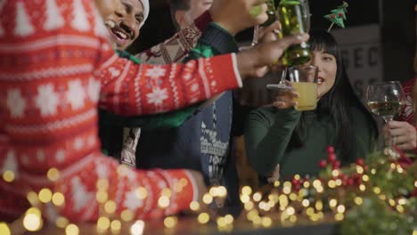 low angle shot of a drunk man with his friends during christmas celebrations at a bar