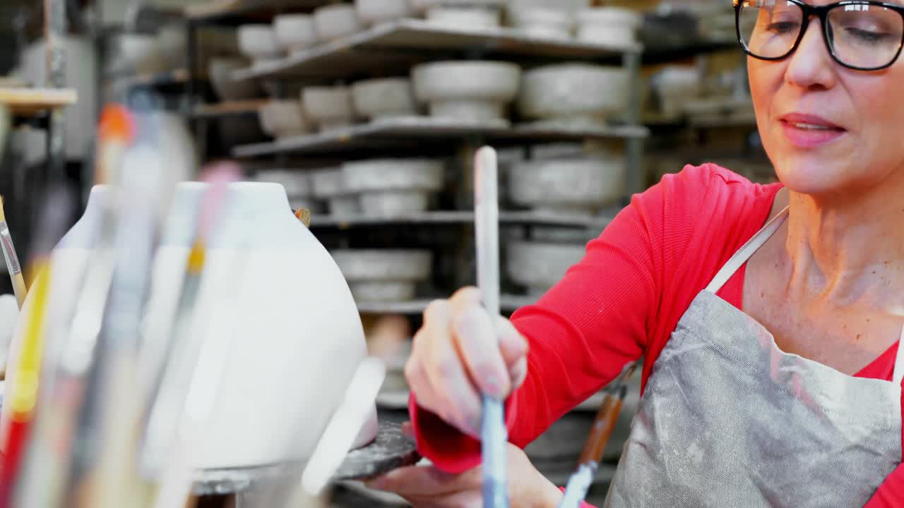 mujer alfarera decorando el cuenco 4k