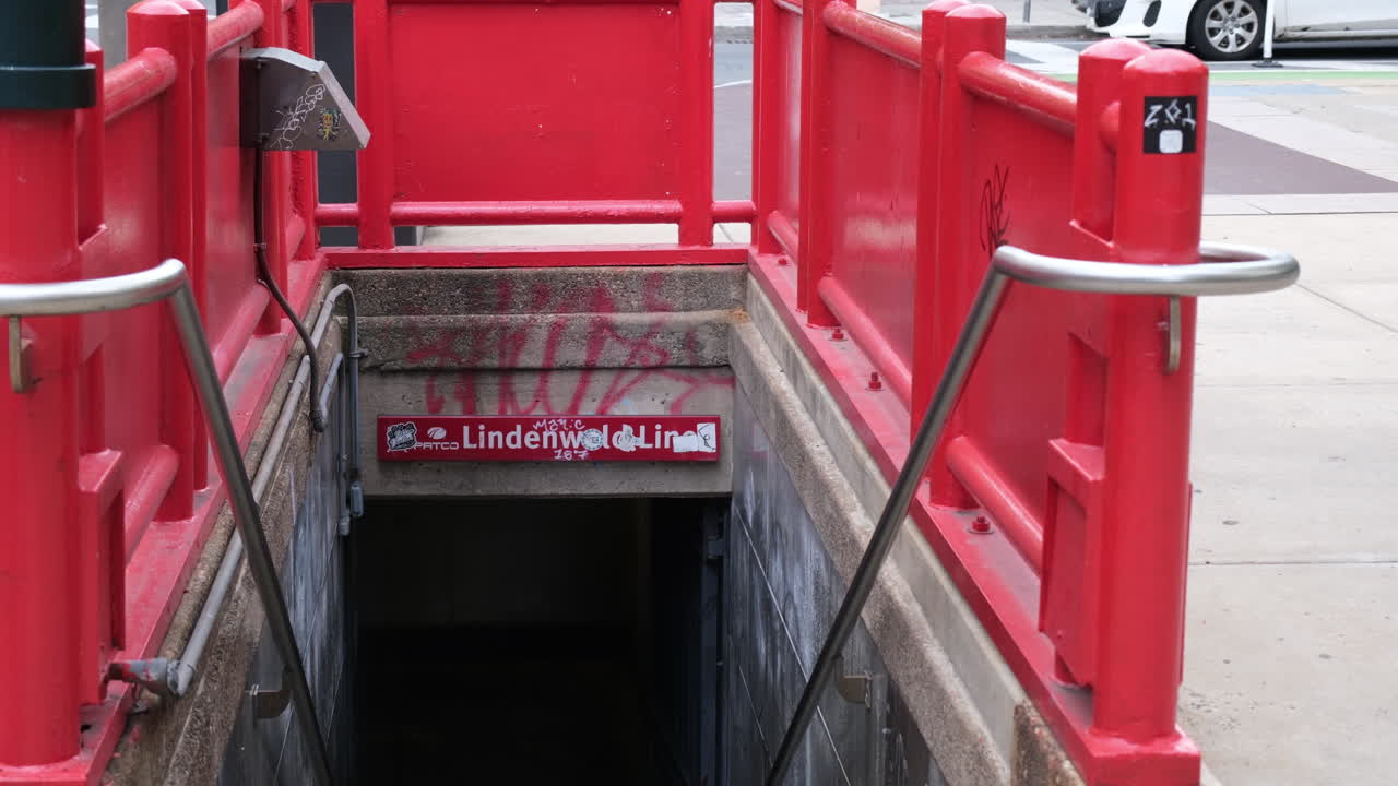 Subway entrance with red railing and graffiti for Lindenwold Line in Center City Philadelphia