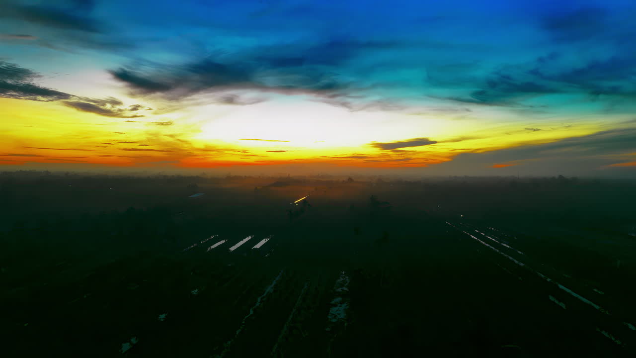 взлетайте над захватывающим дыханием пейзажем, когда первые лучи рассвета освещают огромное пространство сельскохозяйственных угодий, покрытых эфирным утренним туманом.