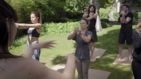 sportive people stretching arms in park