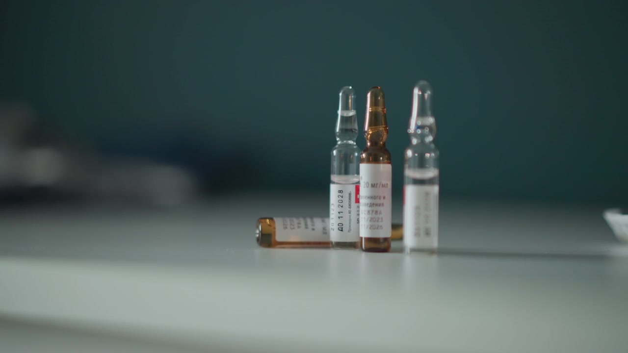 Allestimento organizzato per la preparazione farmaceutica. Raggruppamento preciso di fiale e flaconi medici. Assemblaggio metodico di contenitori di farmaci con etichette in ambiente di laboratorio sterile.