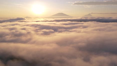 aerial hyperlapse sea of clouds and sun rising on the horizon with mountains