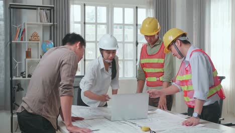 three asian engineers with helmets using laptop for working to a man at the office