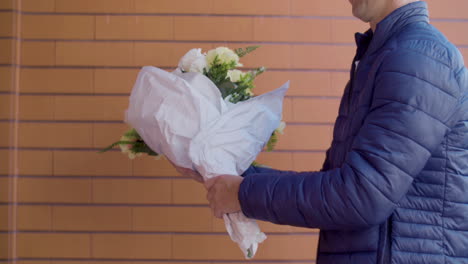 courier delivering bouquet of flowers to a mature woman at her home