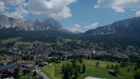 Flying-Over-Stunning-Cortina-Valley-Towards-Rising-Mountains,-Italy